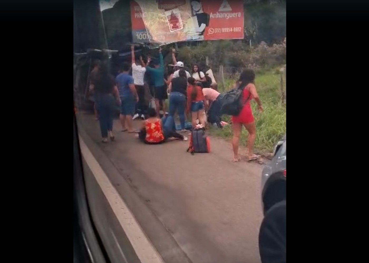 Passageiros se ajudam após van tombar em acidente na BR-356, em Campos; VÍDEO